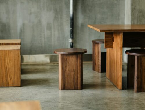 a group of wooden tables and stools in a room
